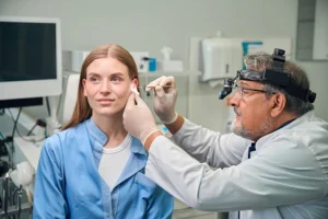 hearvana adult doctor using medical tool to inspect ear
